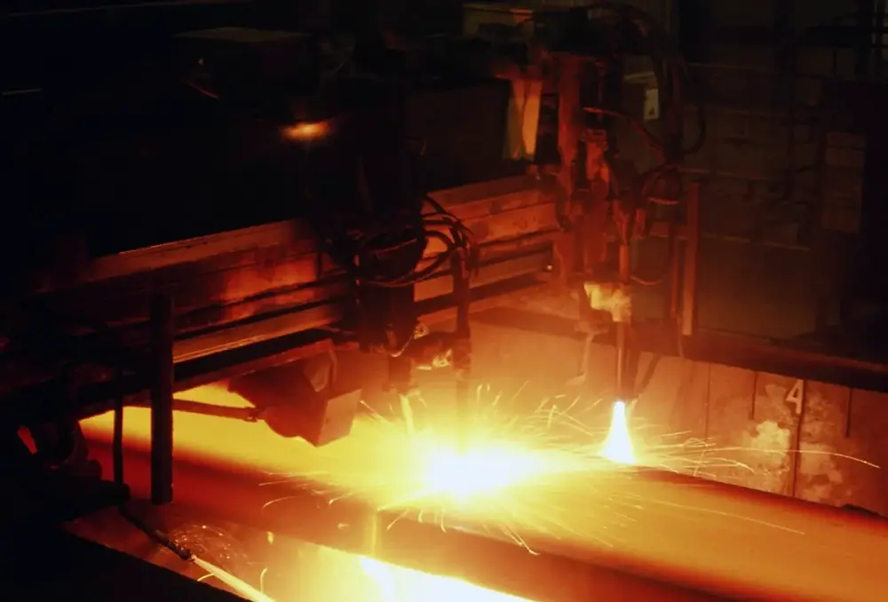 Heat-cut steel plate glowing in a fabrication shop